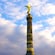 The statue of an angel holding a scepter and a laurel wreath stands atop a massive tower